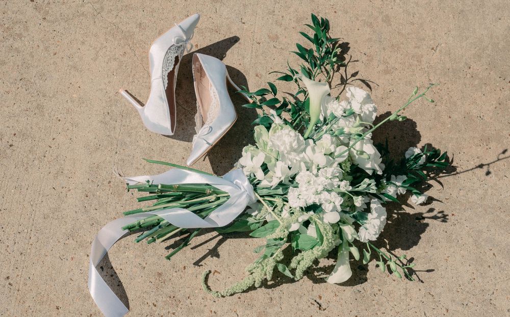 White floral bouquets with green foliage arranged on a beige textured surface.
