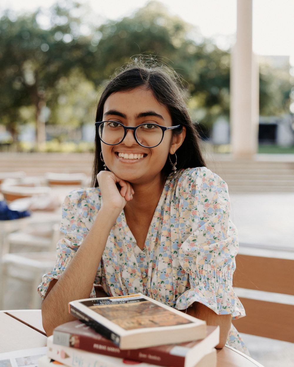 San Antonio Graduation. A student studies outdoors at a table while wearing a floral print dress.