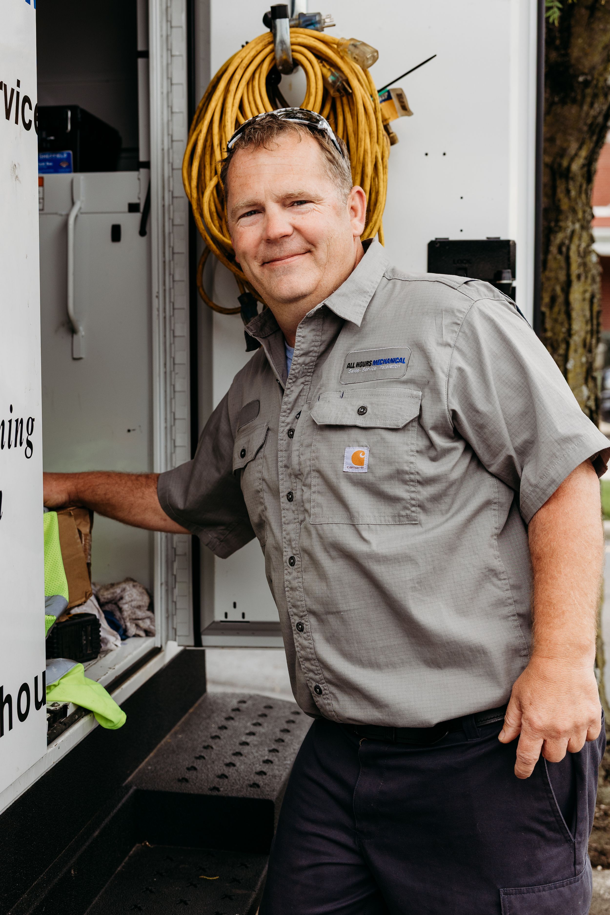 Four sequential images show a person in a gray work uniform with yellow dreadlocks posing near industrial equipment.
