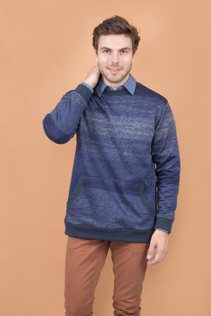 Navy blue heather sweater layered over collared shirt paired with brown pants against beige background.
