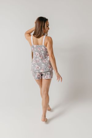 Person wearing a floral print matching loungewear set poses while sitting against a white studio background.