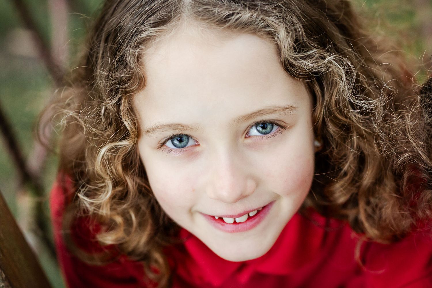 A school girl looks to camera and smiles naturally at a school photo mini session. She looks happy and relaxed. Bristol school photography