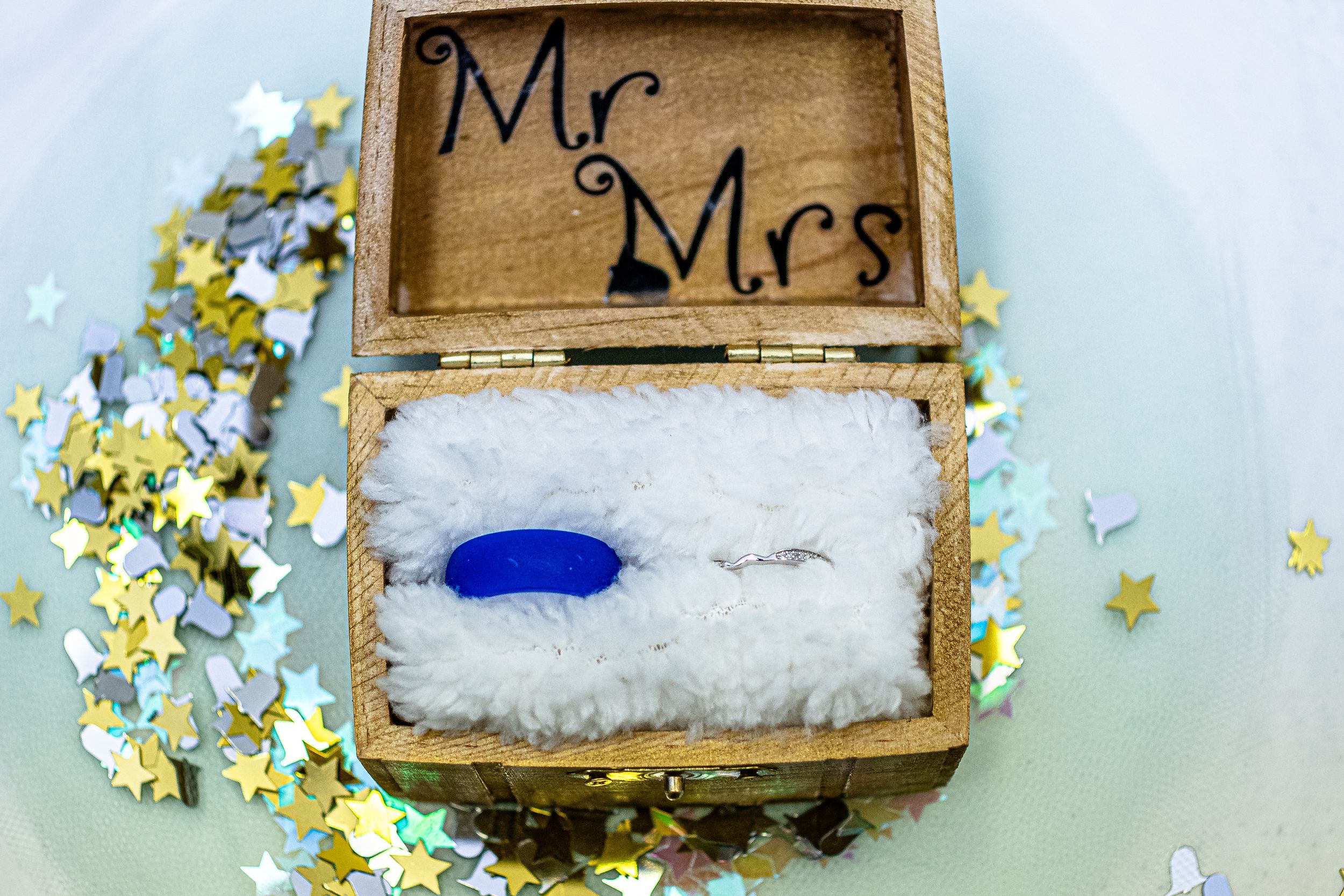 Wooden wedding ring box with 'Mr & Mrs' text decorated with delicate yellow flowers and a blue ring cushion inside.