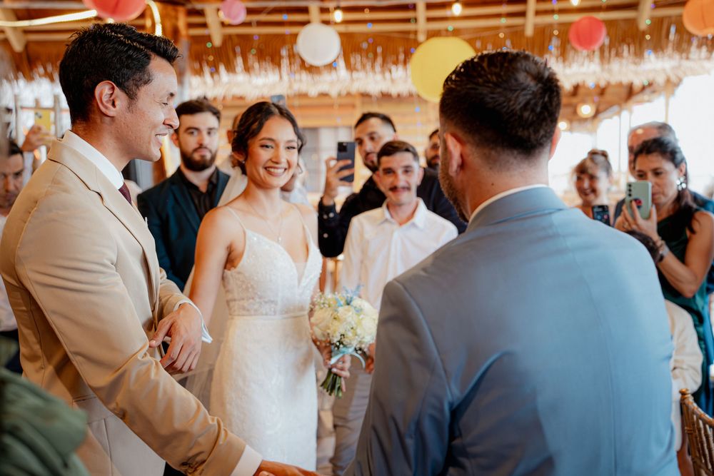 Wedding guests dance and celebrate under hanging paper lanterns at a tropical beach reception venue.