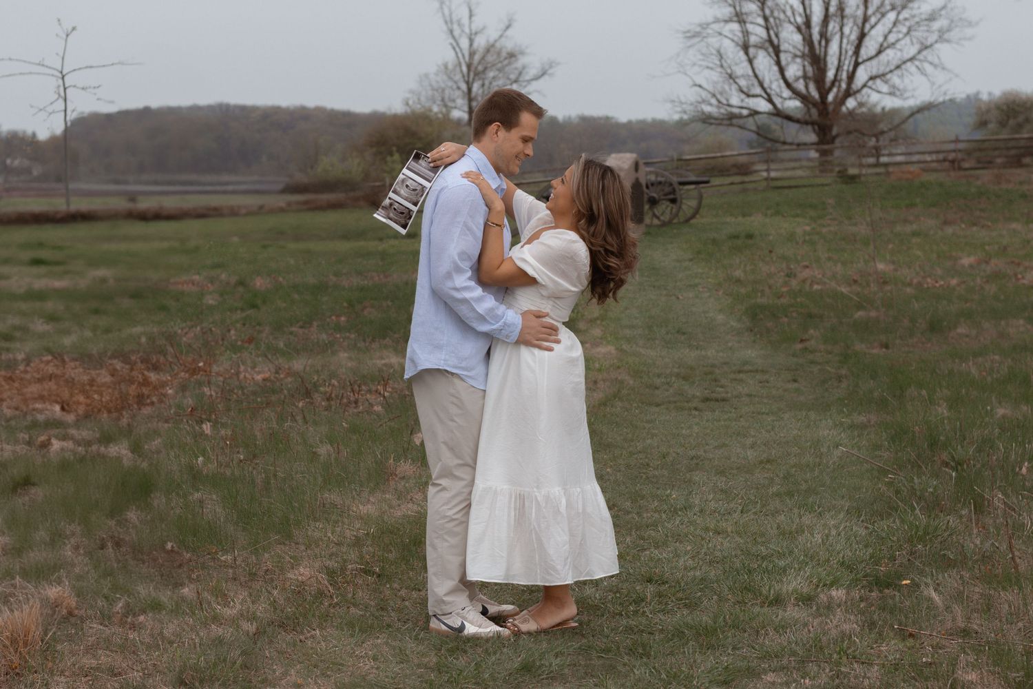 A romantic outdoor engagement photo session in a rustic field setting.