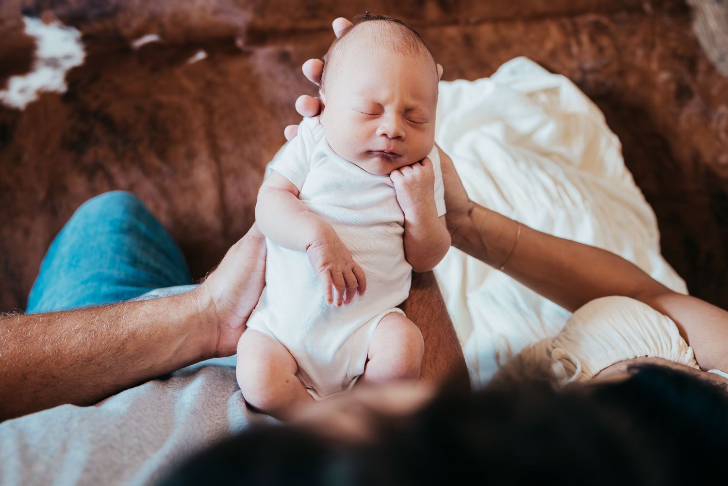 New family cuddling their newborn during in-home lifestyle session in Stuart Florida, newborn photographer in home session, treasure coast