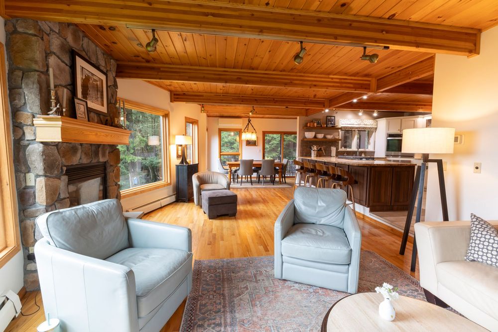 Rustic living room with wood-paneled ceiling and comfortable seating arrangements shown from multiple angles.