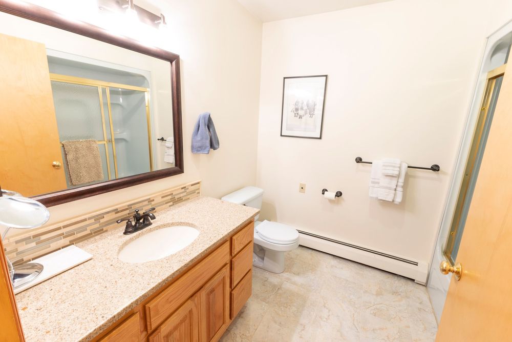 Clean white bathroom with granite countertops and ample storage shown from multiple viewpoints.