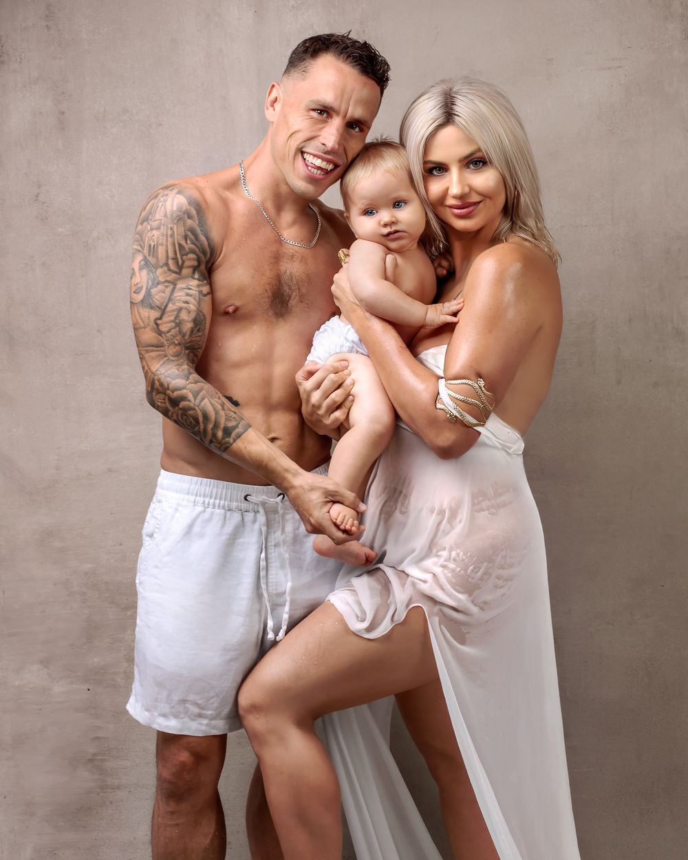 Family photo session, mother standing with partner holding their daughter, their foreheads touching in Caz Captures Sydney studio.