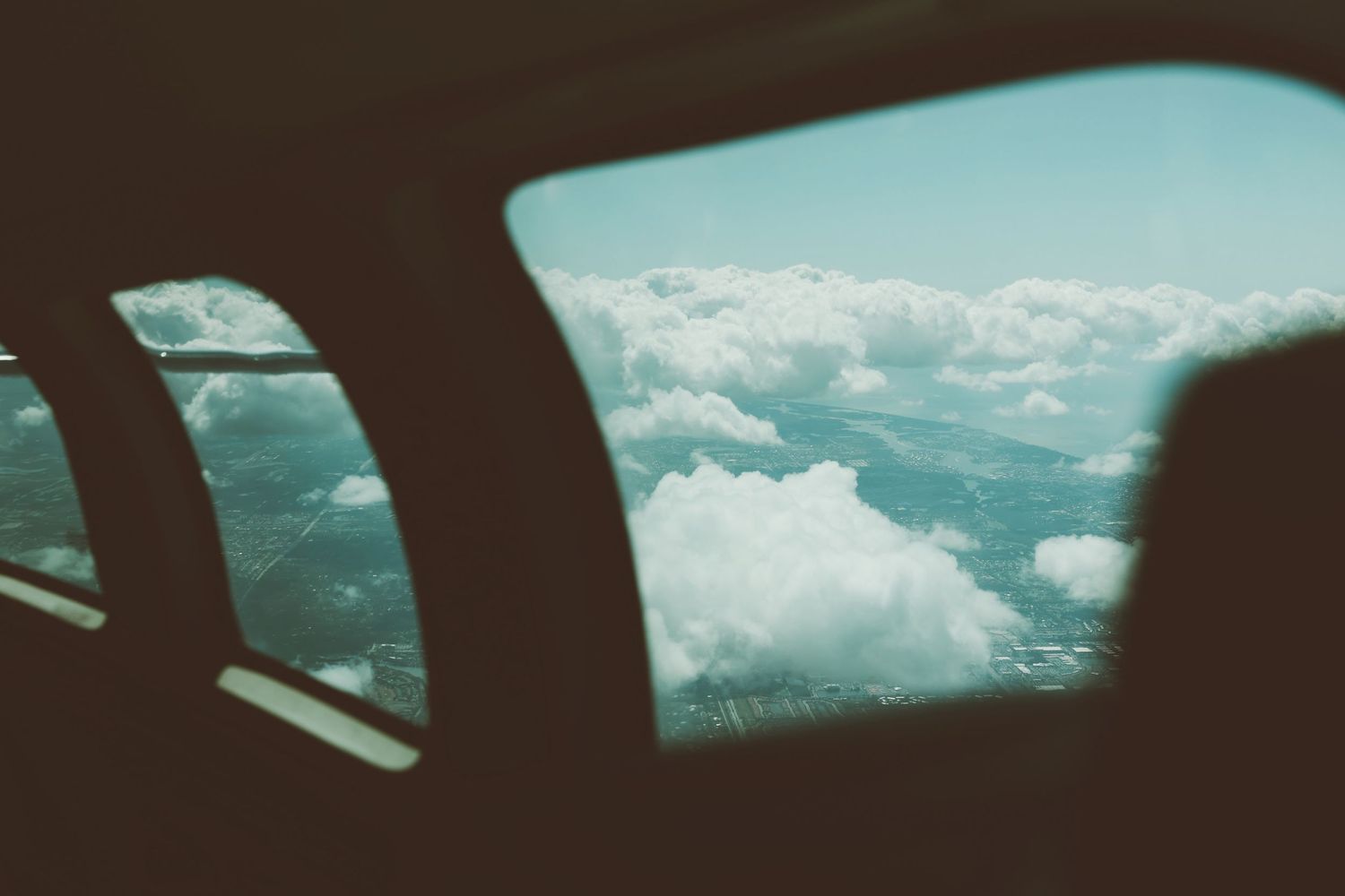 A panoramic sequence of aerial views over fluffy white clouds against a blue sky with sunlight peeking through.