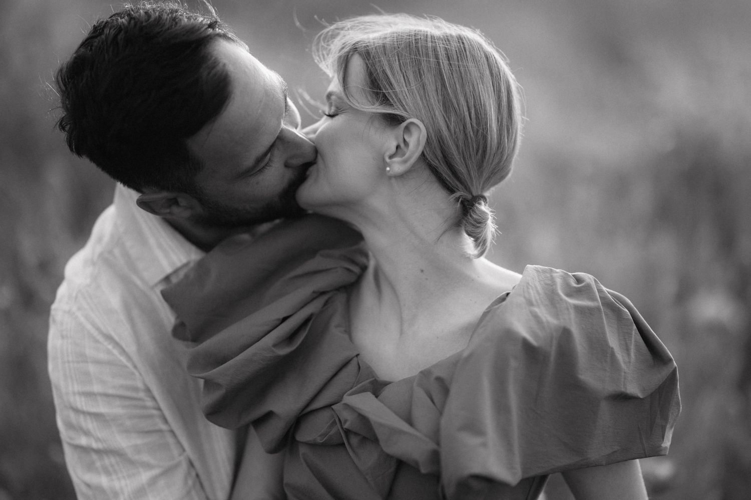 Four black and white romantic photos showing tender moments between a couple on their wedding day.