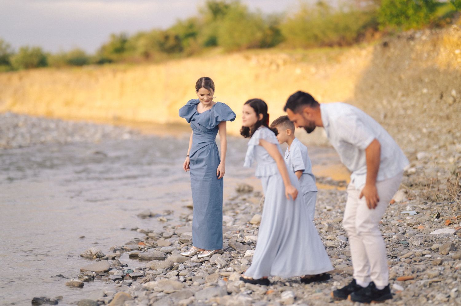 People stroll together on a rugged coastline with cliffs and water views during golden hour.