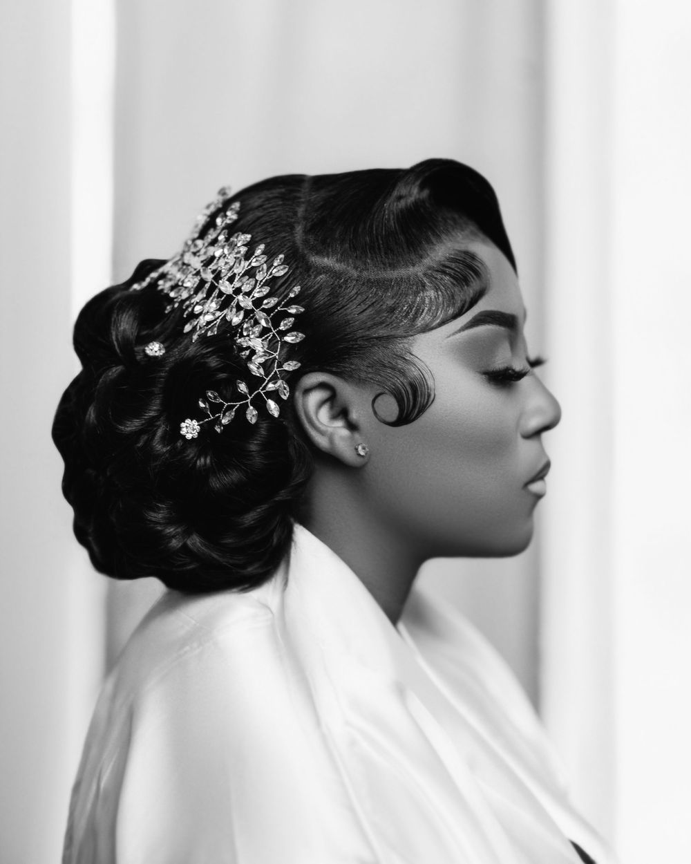 Black and white portrait featuring an elegant updo hairstyle adorned with a crystal hair accessory.