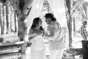 An intimate dance moment captured in black and white under a wooden pavilion.