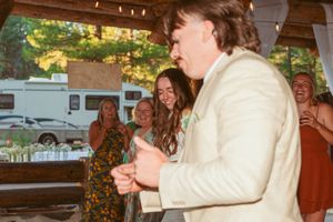 Dance celebration at a rustic outdoor wedding venue with string lights.