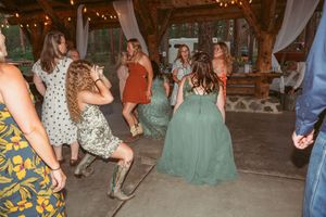 A group of dancers in flowing dresses enjoy a social dance event on an outdoor patio at night.