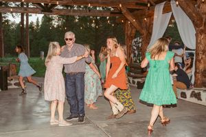 People gathered at an outdoor venue celebrating with dancing and socializing at dusk.