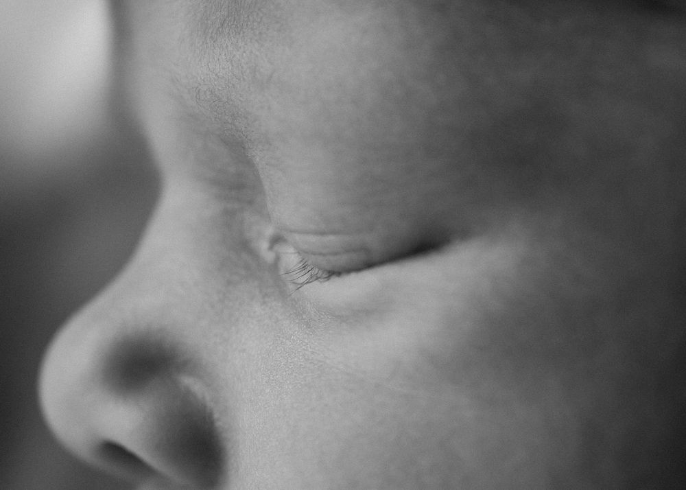Close up macro black and white image of newborn's eyelashes, soft and dreamy