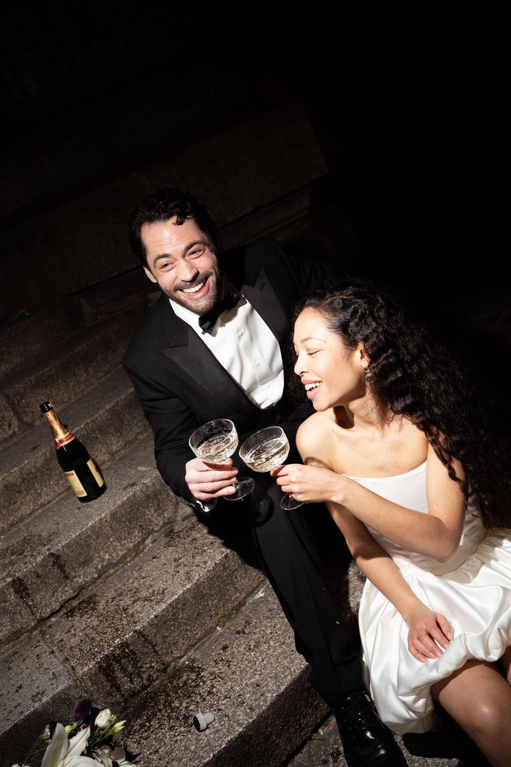 A couple in formal attire shares wine and laughter together in a series of candid photographs.