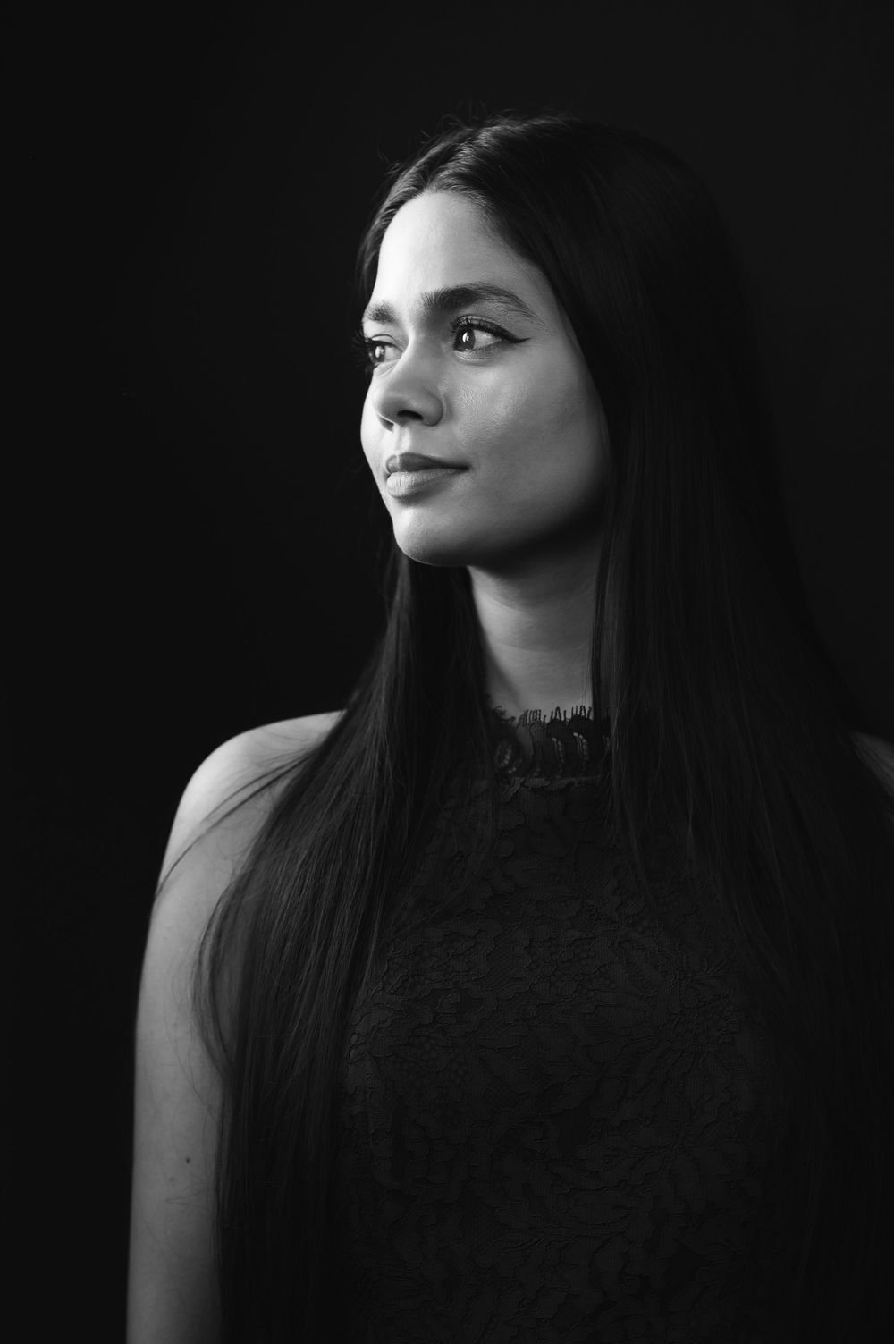 Elegant black and white side profile portrait of a young woman with long straight dark hair.