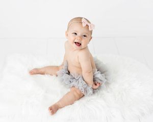 6 month old baby girl smiling in professional Menifee photographer's studio.