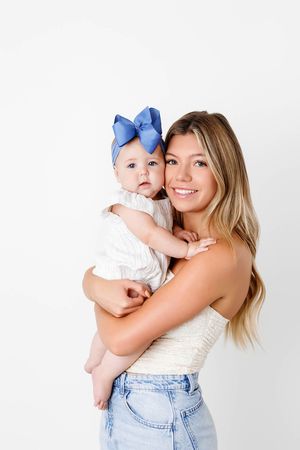 Big sister holding her baby sister in Murrieta California photography studio.