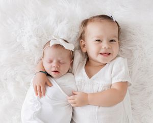 Sibling photoshoot of new baby and toddler sister by San Diego area newborn photographer.