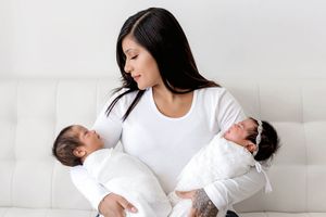 Professional newborn twins photographer photo of mom holding fraternal twin babies.