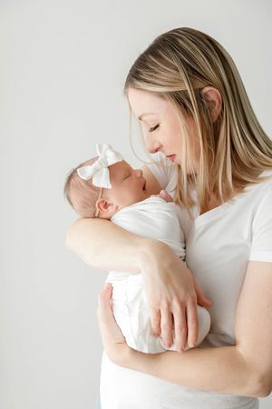 Mom holding her newborn baby daughter, professional newborn photography in Murrieta.