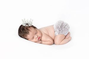 Inland Empire professional newborn photographer in Menifee: Sleeping baby girl wearing a tiny silver tiara.