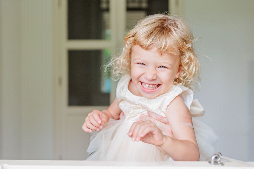 laughing blonde curly child in white colonial building