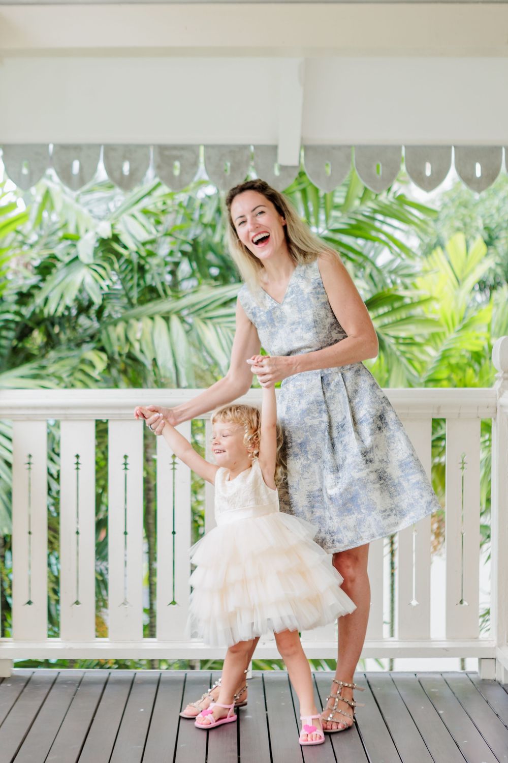 A Relaxed Family Photoshoot in a Singapore Condo. Russian caucasian mom with a blond curly hchild in light wooden balcony with green foliage