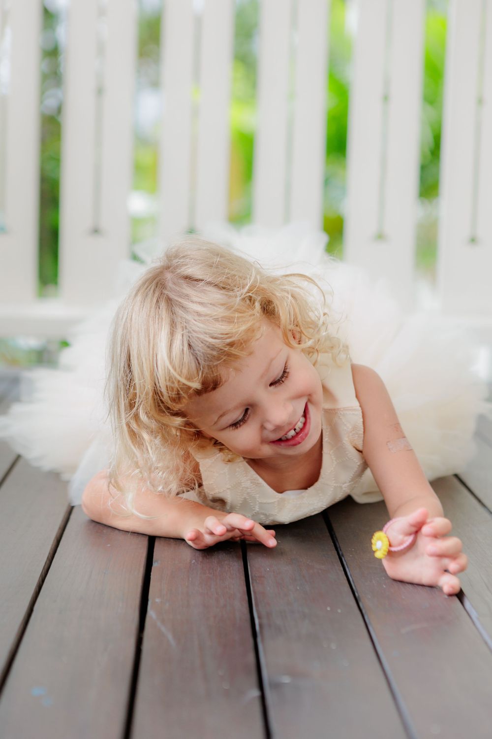 laughing blonde curly child in white colonial building. Playing on wooden floor