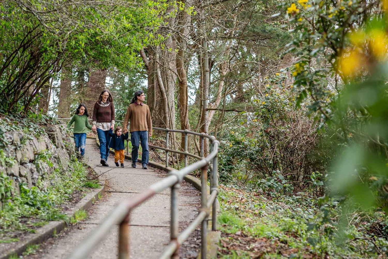 Family walking paved pathway with rail providing leading line.