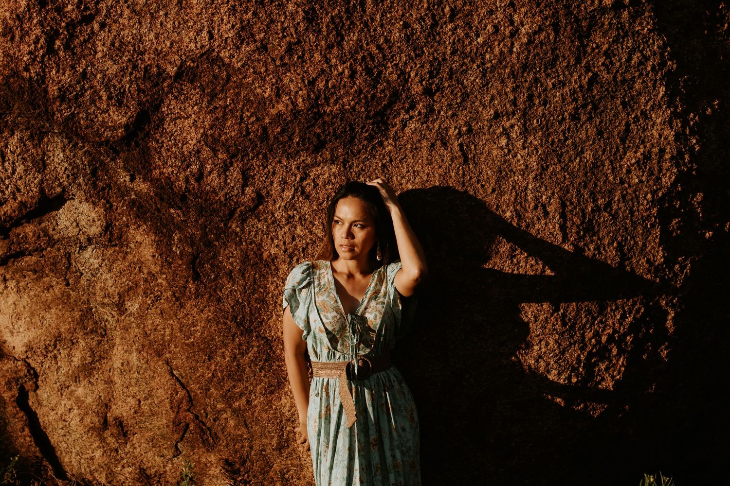woman poses in front of boulders at the granite mines