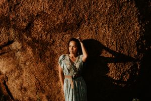 woman poses in front of boulders at the granite mines