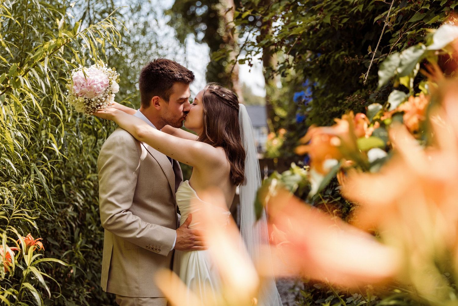 Couple kiss in the gardens at Lakeside Hotel