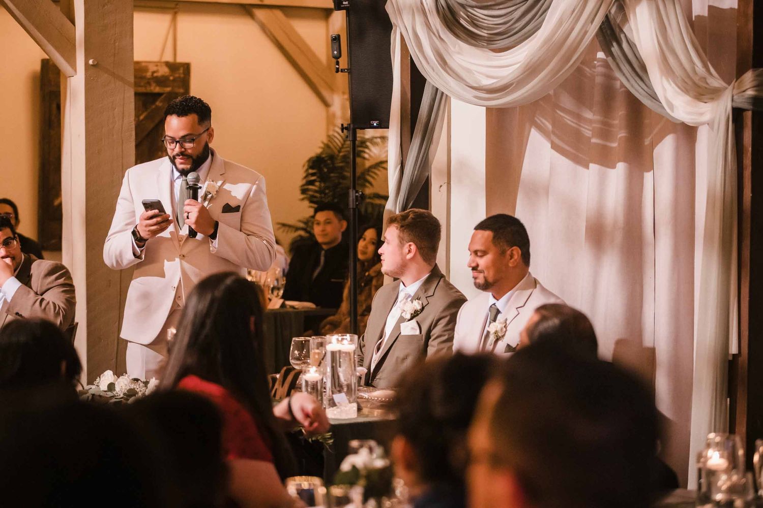 Best man giving wedding speech while grooms listen at Briar Barn Inn reception