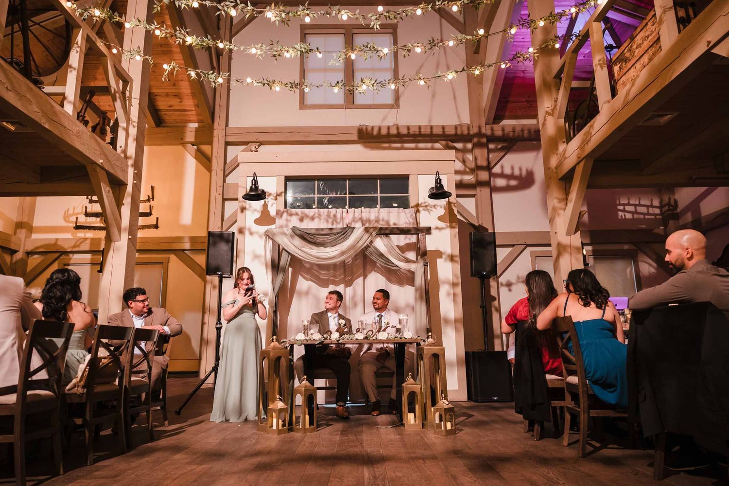 Wide view of wedding speech at Briar Barn Inn with guests gathered around head table