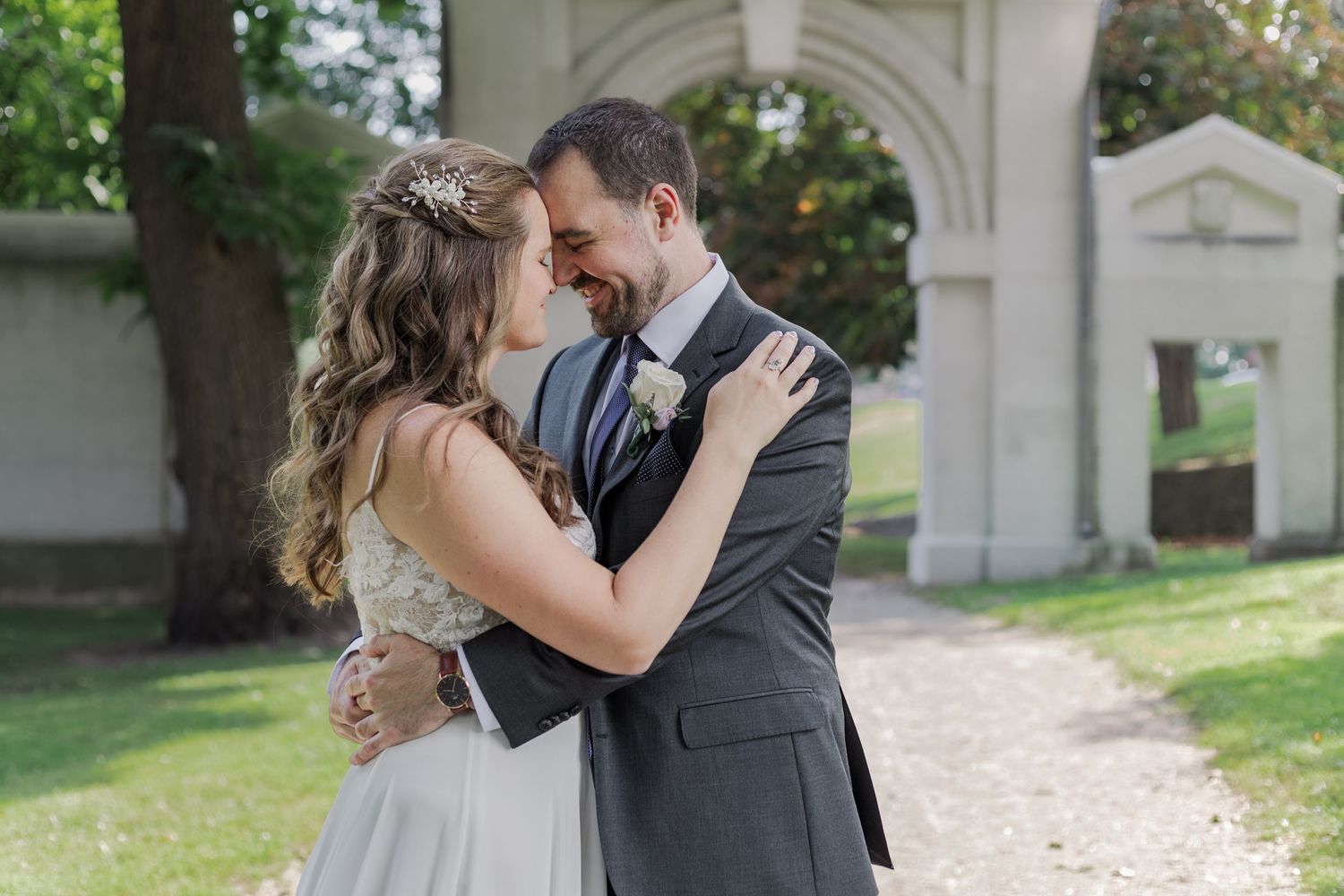 Natural wedding photography of bride and groom snuggling together on the grounds of the dundurn castle in hamilton, ontario.