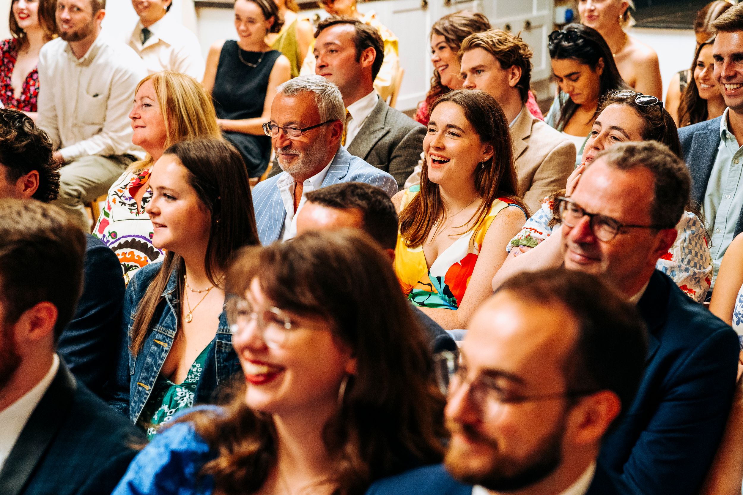 Happy wedding guests laugh and smile during a joyful ceremony celebration.
