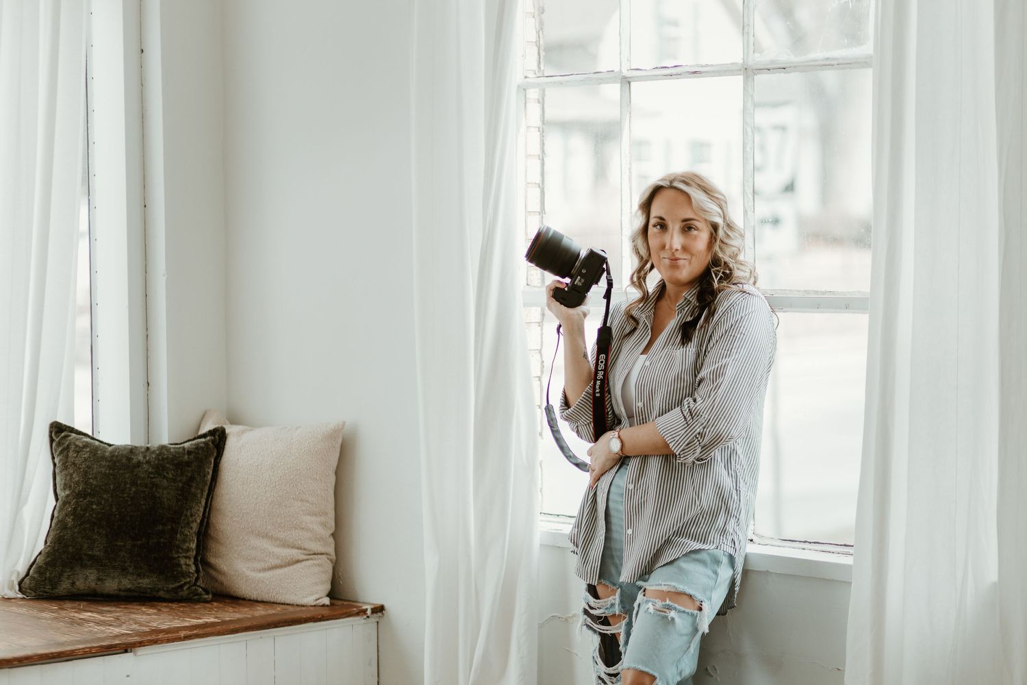 Professional photographer works in bright white studio space with natural window light.