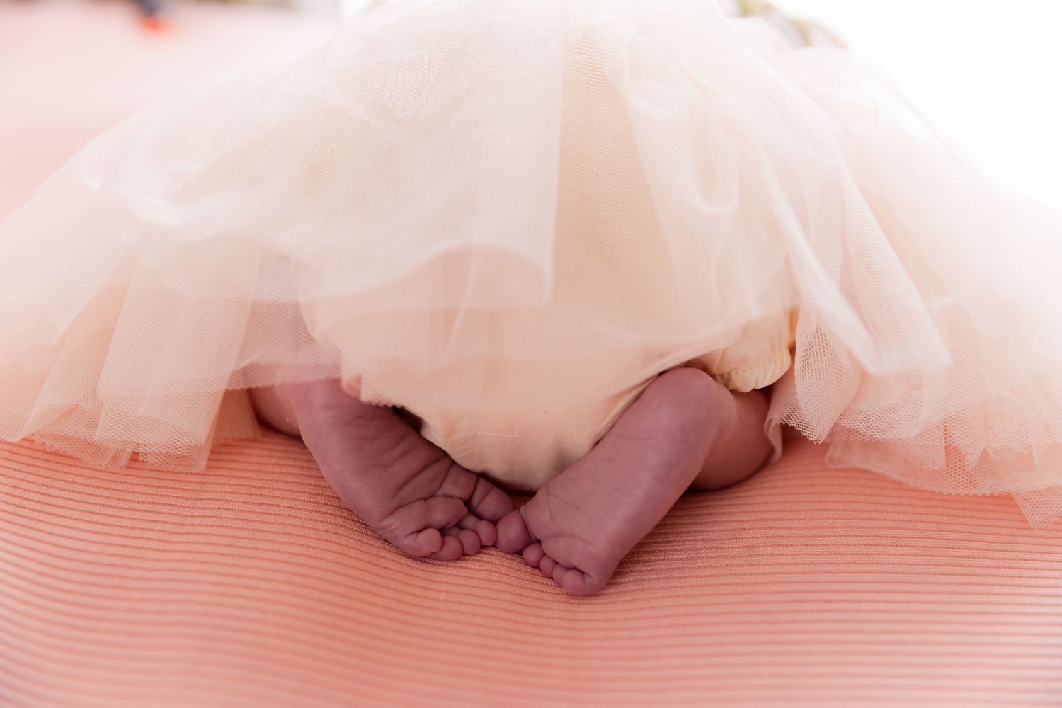 Babys feet on peach coloured blankets