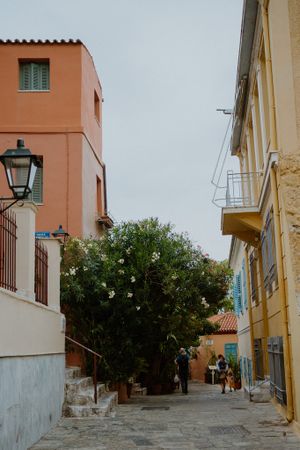 Colorful buildings line a narrow cobblestone street in a Mediterranean neighborhood with traditional architecture.