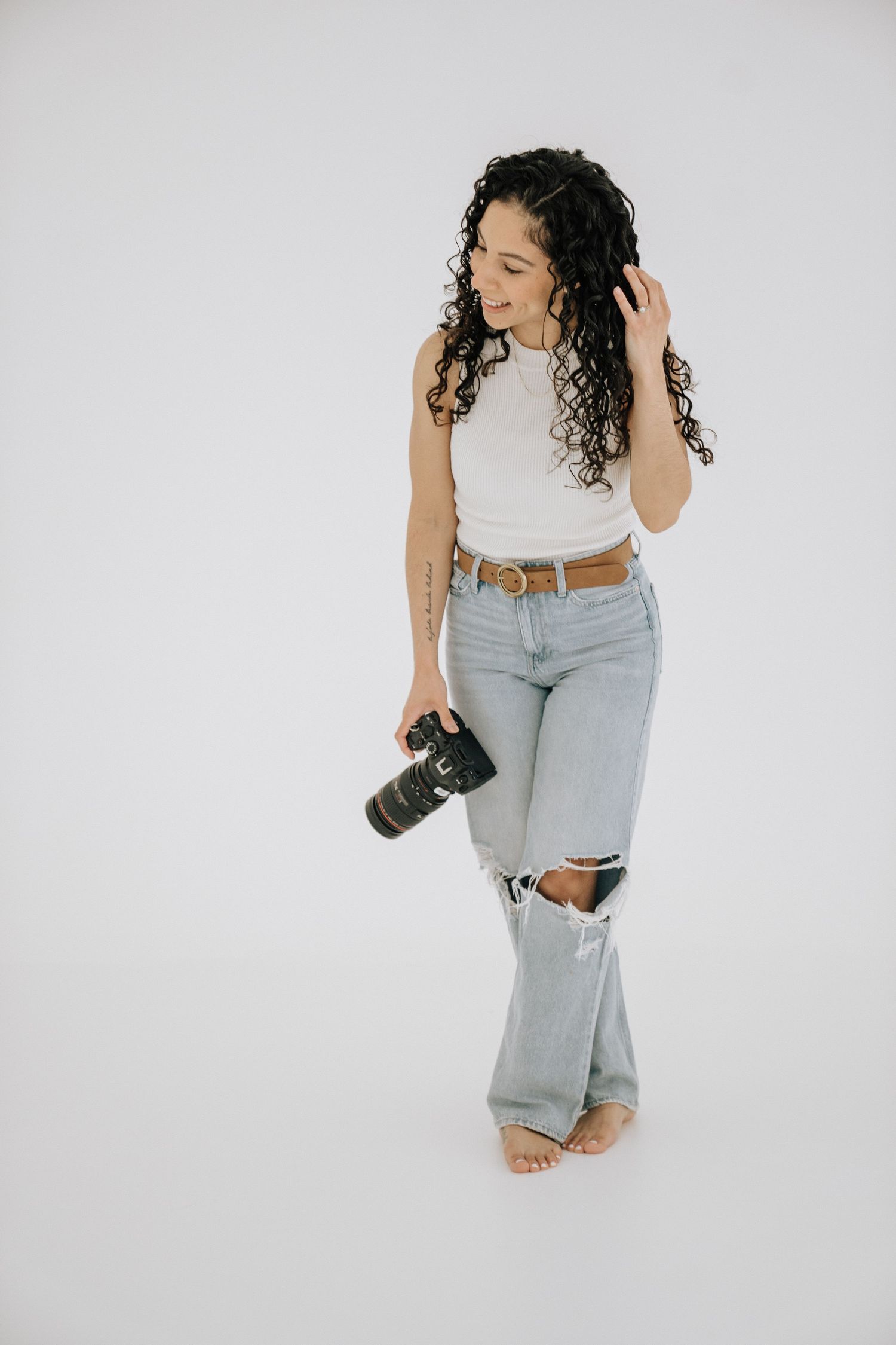 wedding and lifestyle photographer in Rochester, ny, holding a camera