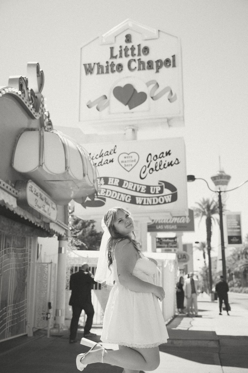 Black and white photo capturing a joyful moment outside Las Vegas' famous Little White Chapel.