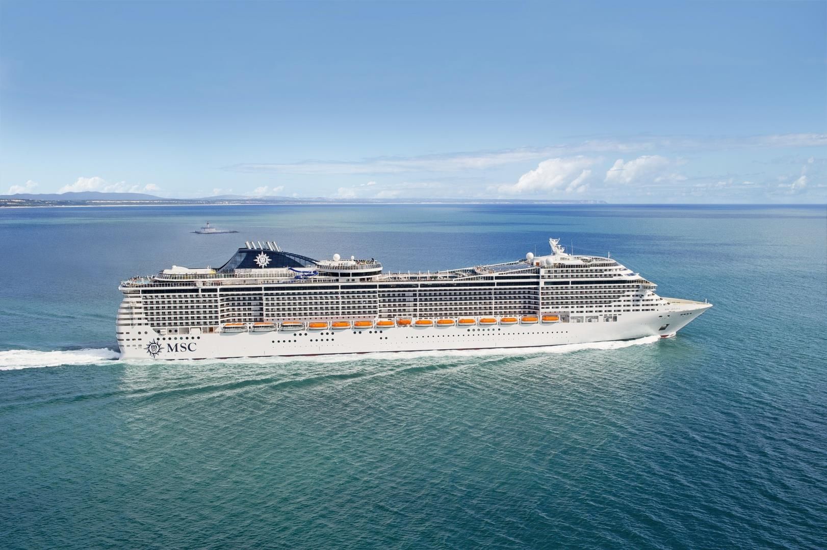 Large white MSC cruise ship sailing across calm blue ocean waters on a sunny day with clear skies.