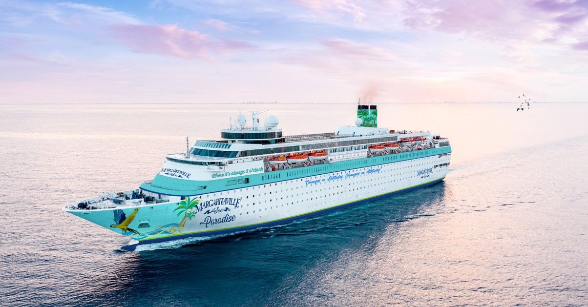 Large white and turquoise cruise ship sailing across calm ocean waters during sunset with colorful sky.