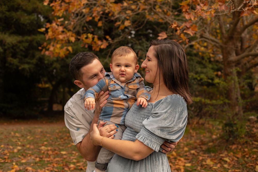 Sweet family moments captured during a fall photoshoot in a park setting.