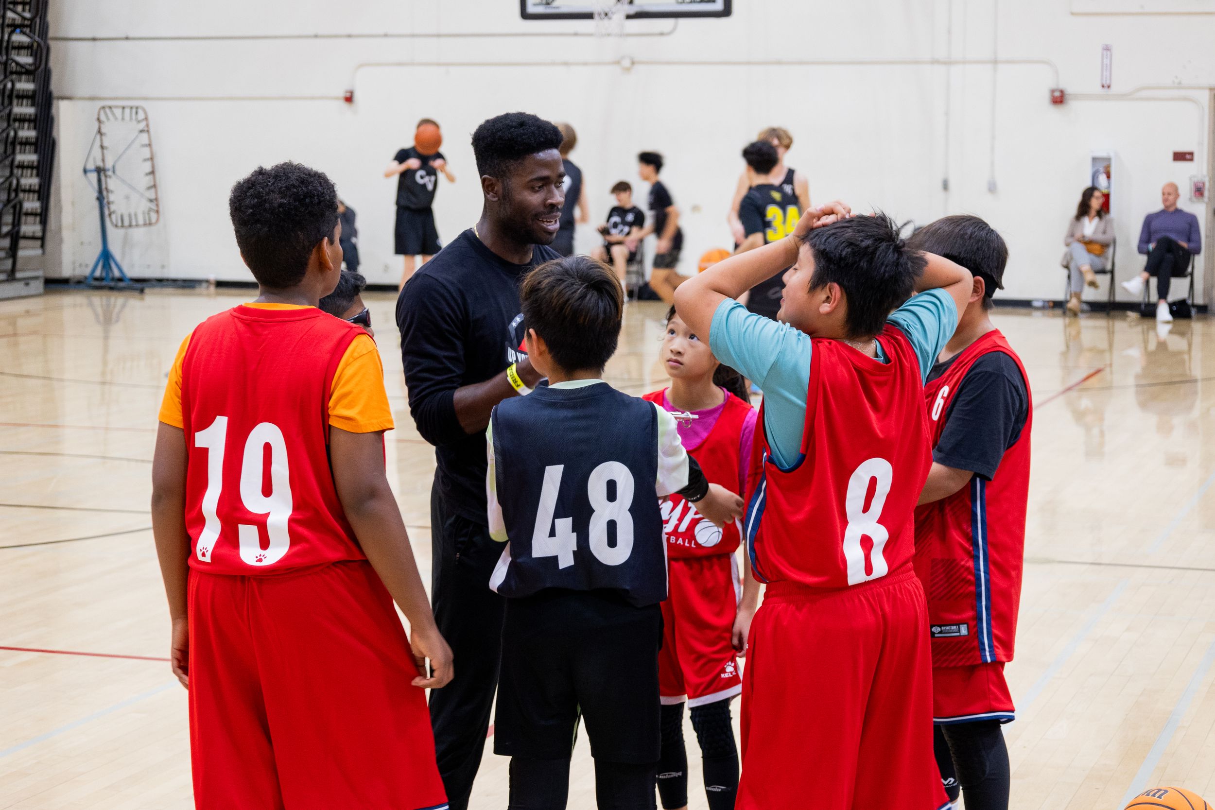 Youth team basketball team huddle listening to direction given from their coach. Up Your Performance club team. Sports photography